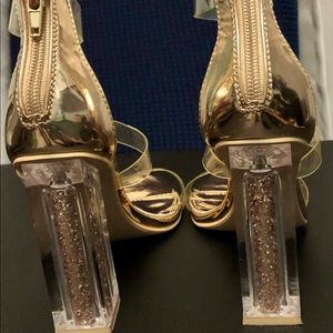 Gold-tone dressy sandals with clear glitter heel.